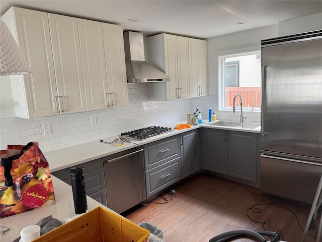 163-18 Cryders Ln, Whitestone, NY 11357 - kitchen with wall chimney range hood, appliances with stainless steel finishes, gray cabinets, wood finished floors, and tasteful backsplash