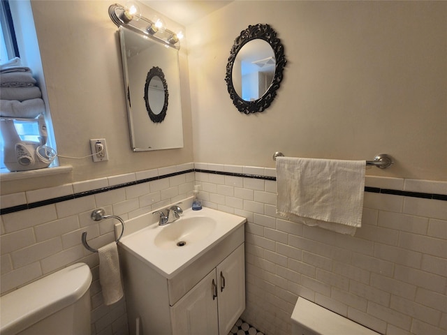 79 N Broadway Unit H, White Plains, NY 10603 - bathroom with tile walls, toilet, a wainscoted wall, and vanity