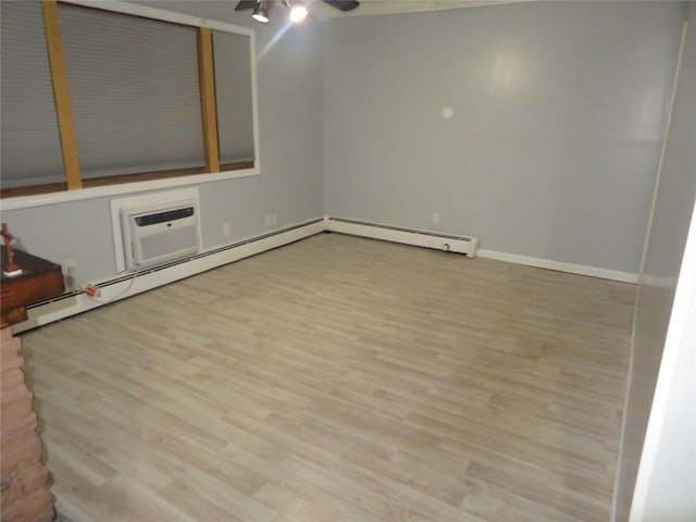 empty room with a ceiling fan, a wall unit AC, wood finished floors, and baseboard heating