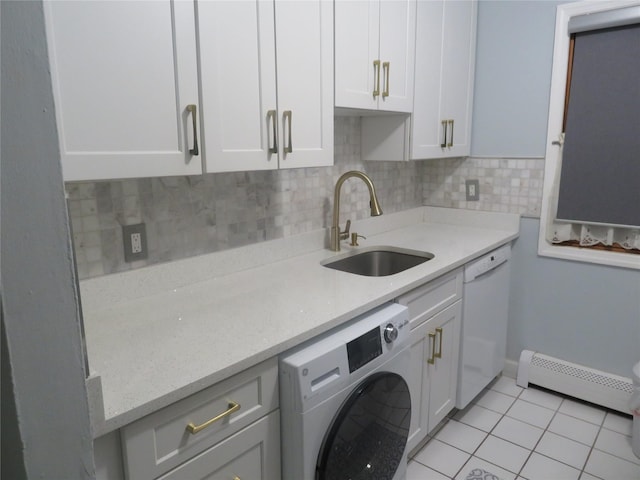 washroom featuring washer / clothes dryer, baseboard heating, cabinet space, and light tile patterned flooring