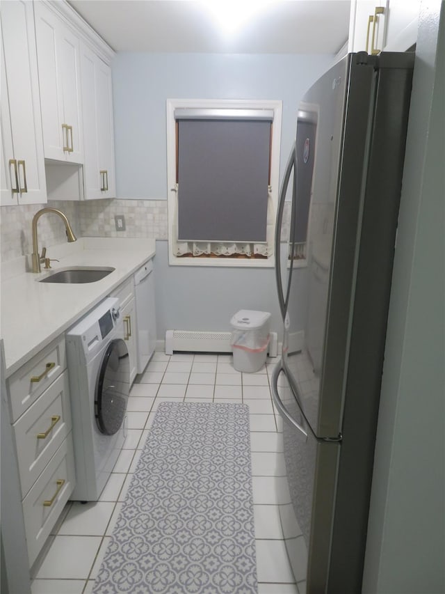laundry area featuring washer / clothes dryer, a sink, light tile patterned floors, and baseboard heating