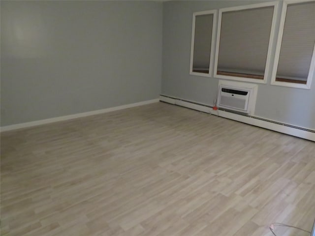 empty room with light wood-style flooring, baseboards, and baseboard heating