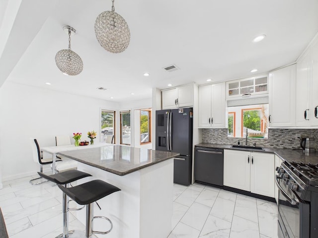 kitchen with black appliances, light marble finish flooring, a sink, a kitchen island, and recessed lighting
