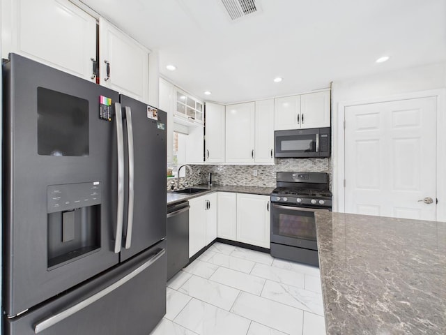 kitchen with fridge with ice dispenser, gas range oven, stainless steel dishwasher, a sink, and white cabinetry