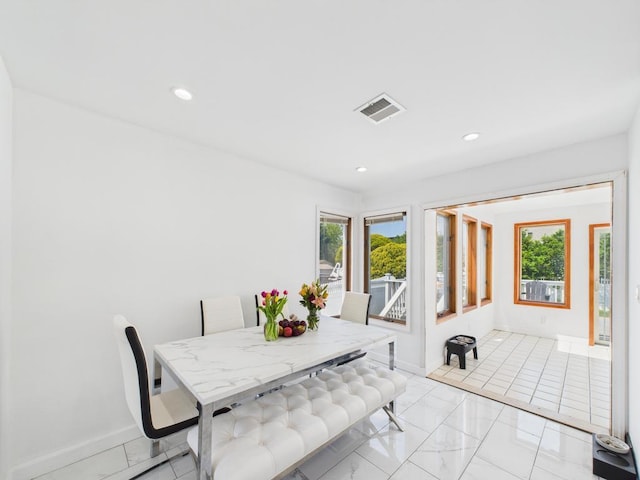 dining room featuring plenty of natural light, baseboards, recessed lighting, and light marble finish flooring
