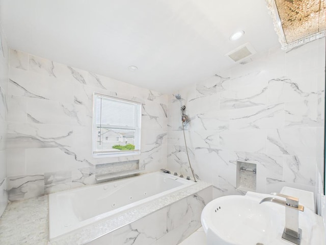 bathroom with a whirlpool tub, a sink, a marble finish shower, and recessed lighting