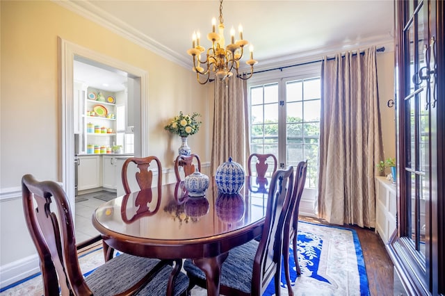 dining room with a chandelier, crown molding, and wood finished floors
