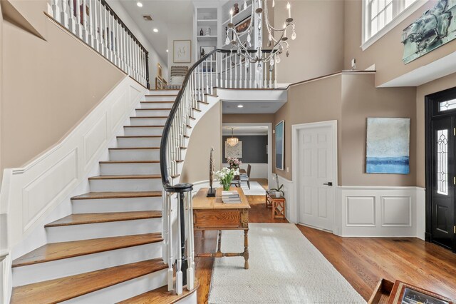2 Cerf Ln, Mount Kisco, NY 10549 - foyer entrance featuring a chandelier, wood finished floors, stairs, a towering ceiling, and plenty of natural light
