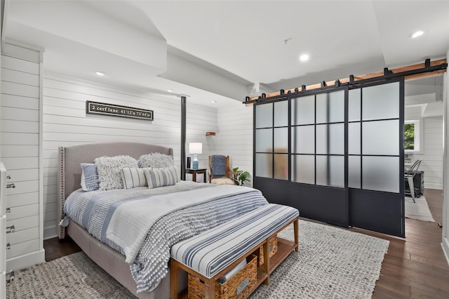2 Cerf Ln, Mount Kisco, NY 10549 - bedroom with a barn door, hardwood / wood-style floors, recessed lighting, and wood walls