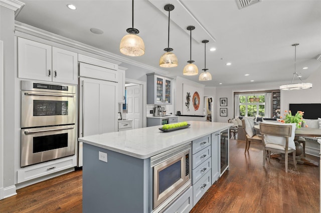 2 Cerf Ln, Mount Kisco, NY 10549 - kitchen with appliances with stainless steel finishes, open floor plan, ornamental molding, dark wood finished floors, and a kitchen island