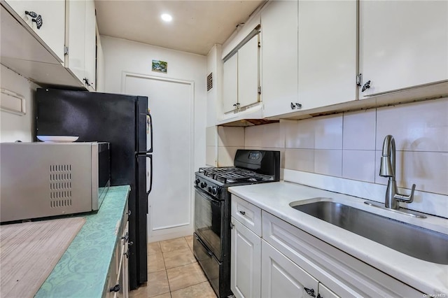 kitchen with black gas stove, stainless steel microwave, a sink, white cabinets, and recessed lighting