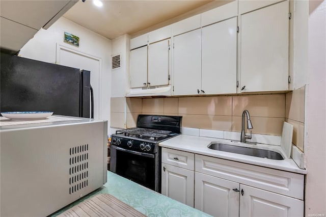 kitchen featuring black appliances, a sink, light countertops, under cabinet range hood, and white cabinetry