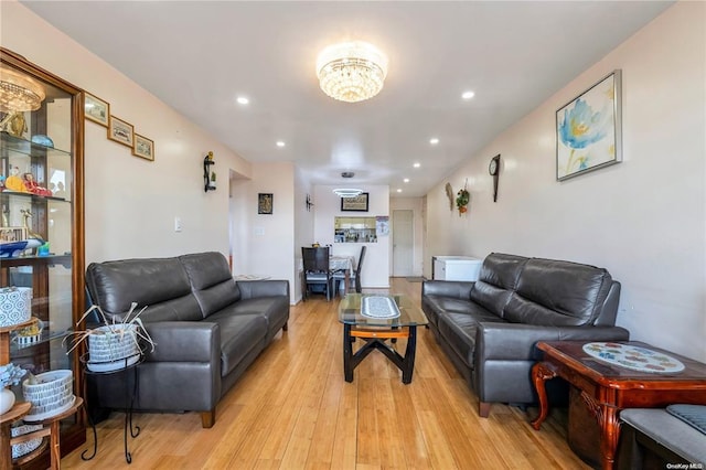 living area featuring light wood-style floors, recessed lighting, and a chandelier