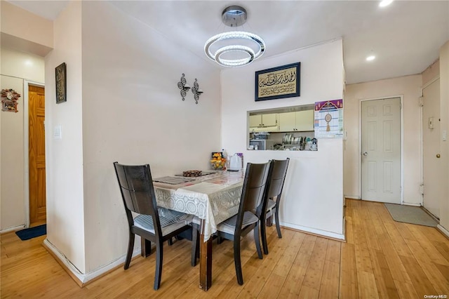 dining room featuring light wood-style flooring, recessed lighting, and baseboards