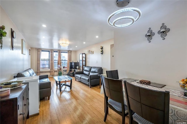 living room with light wood finished floors, a chandelier, and recessed lighting