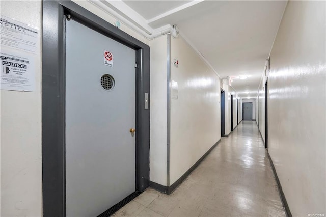 corridor with light floors and baseboards