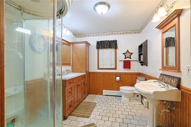 full bathroom featuring a baseboard radiator, a wainscoted wall, a shower stall, toilet, and wood walls