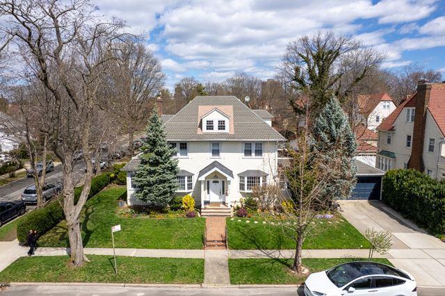 7203 Ingram St, Forest Hills, NY 11375 - view of front of property with a front yard, stucco siding, and cooling unit