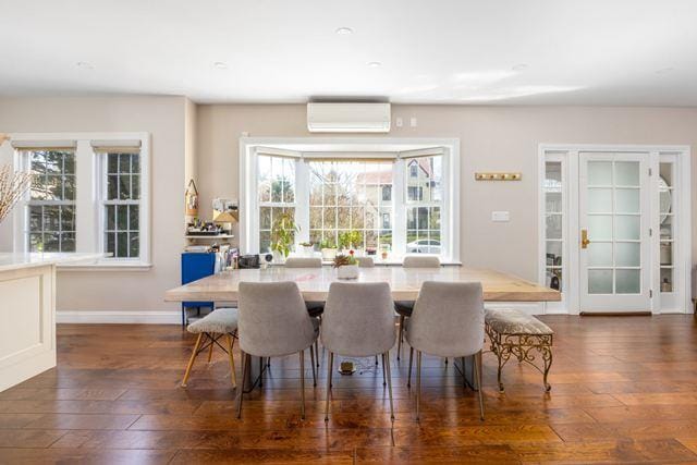 7203 Ingram St, Forest Hills, NY 11375 - dining area featuring an AC wall unit, dark wood-style flooring, and baseboards