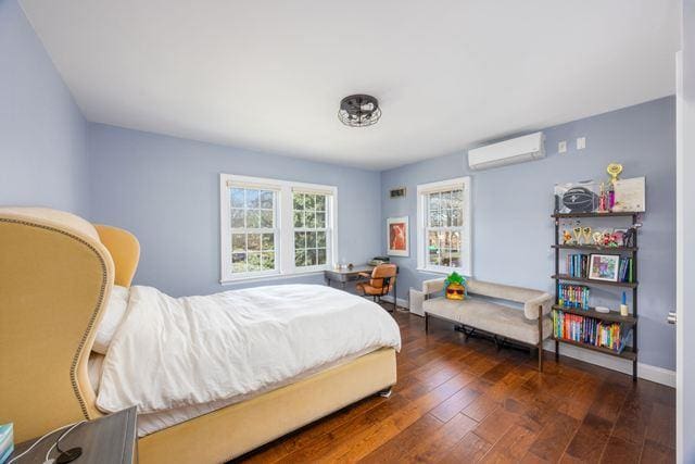 7203 Ingram St, Forest Hills, NY 11375 - bedroom with a wall unit AC, hardwood / wood-style flooring, and baseboards