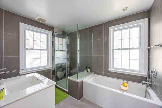 7203 Ingram St, Forest Hills, NY 11375 - bathroom featuring tile walls, a stall shower, plenty of natural light, and tile patterned floors