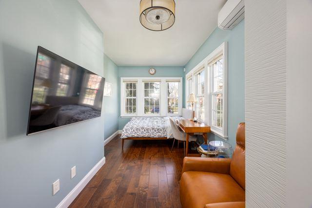 7203 Ingram St, Forest Hills, NY 11375 - bedroom with a wall mounted air conditioner, baseboards, and hardwood / wood-style flooring