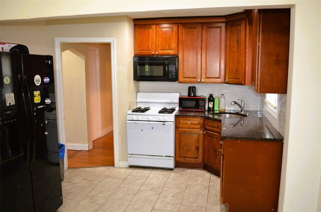 110 Powell Pl, Hempstead, NY 11550 - kitchen with black appliances, a sink, brown cabinets, tasteful backsplash, and dark stone countertops