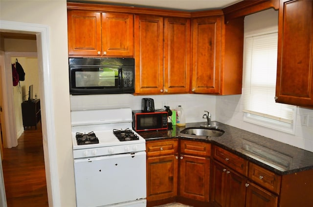 110 Powell Pl, Hempstead, NY 11550 - kitchen with black microwave, white gas range, a sink, and backsplash