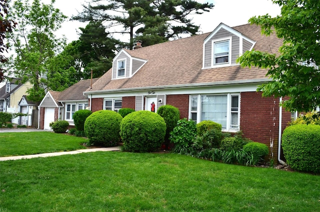 110 Powell Pl, Hempstead, NY 11550 - cape cod home with brick siding, a front lawn, and roof with shingles