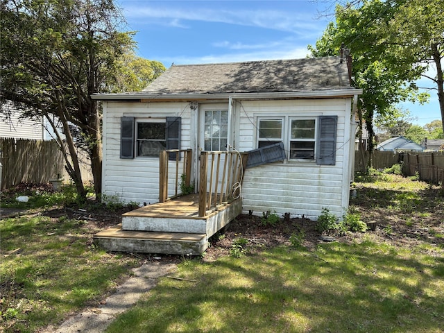 view of front of home featuring a shingled roof and an outdoor structure
