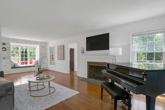 40 Brookby Rd, Scarsdale, NY 10583 - living room with healthy amount of natural light, a fireplace, a decorative wall, and wood finished floors