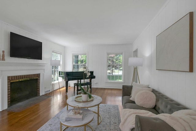 40 Brookby Rd, Scarsdale, NY 10583 - living room with wood finished floors, ornamental molding, a brick fireplace, and a decorative wall