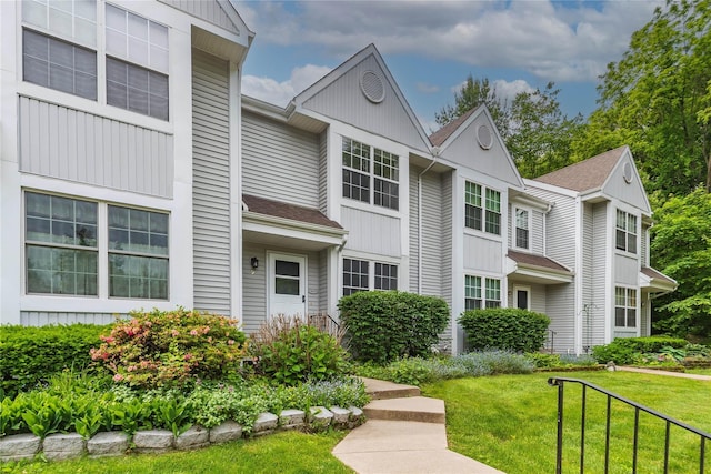9 Clara Ct, Cortlandt Manor, NY 10567 - view of front of house featuring a front yard, a shingled roof, and board and batten siding