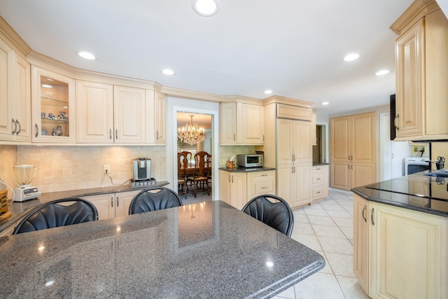 1 Karin Ct, East Northport, NY 11731 - kitchen with a chandelier, decorative backsplash, glass insert cabinets, dark stone counters, and light tile patterned floors