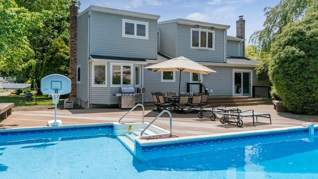 1 Karin Ct, East Northport, NY 11731 - rear view of property featuring a chimney, a wooden deck, and an outdoor pool