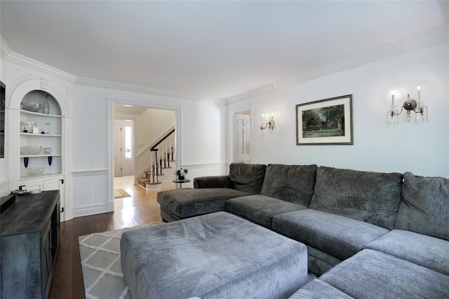 living room with stairs, ornamental molding, and dark wood-type flooring