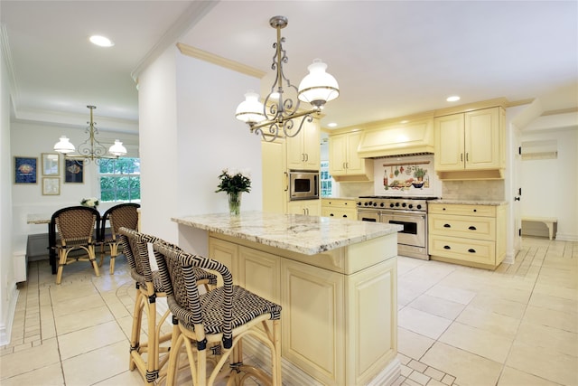 kitchen with stainless steel appliances, a chandelier, cream cabinetry, light stone countertops, and decorative backsplash