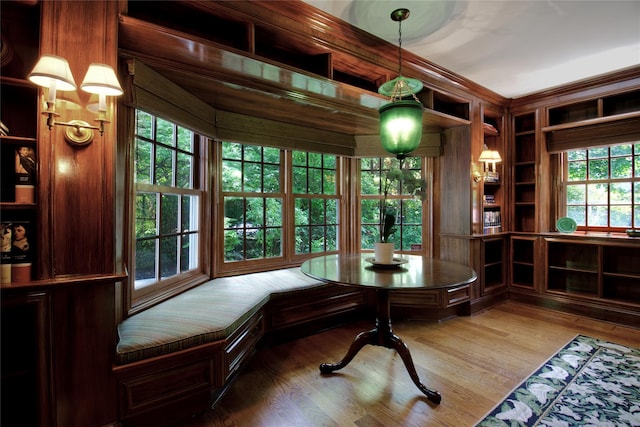 dining room featuring breakfast area, built in features, healthy amount of natural light, and wood finished floors