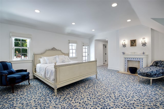 bedroom with carpet flooring, recessed lighting, baseboards, and a tiled fireplace