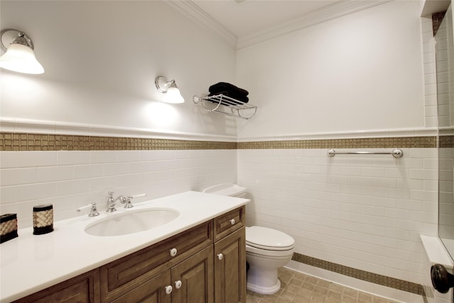 bathroom with toilet, ornamental molding, tile walls, a wainscoted wall, and vanity
