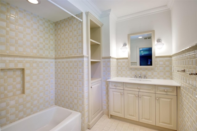 full bath featuring tile walls, tile patterned flooring, crown molding, vanity, and wainscoting