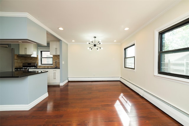 kitchen featuring appliances with stainless steel finishes, baseboard heating, dark countertops, a chandelier, and recessed lighting