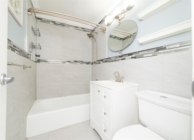 bathroom with toilet, tile walls, tile patterned flooring, vanity, and  shower combination
