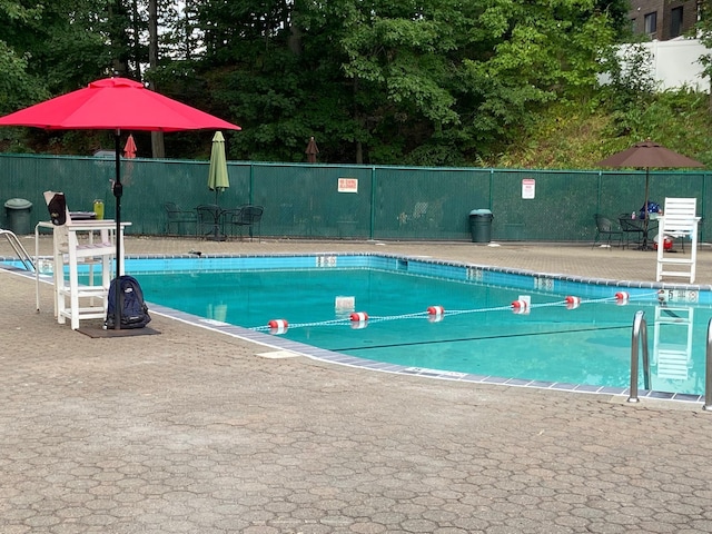 community pool featuring fence and a patio