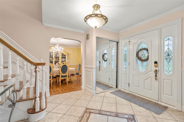 8 Wichard Blvd, Commack, NY 11725 - foyer featuring arched walkways, light tile patterned floors, a chandelier, ornamental molding, and a wainscoted wall