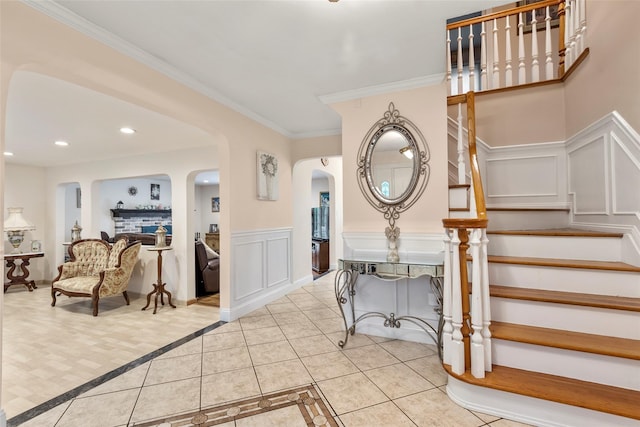 8 Wichard Blvd, Commack, NY 11725 - stairs with a decorative wall, arched walkways, tile patterned floors, ornamental molding, and a wainscoted wall