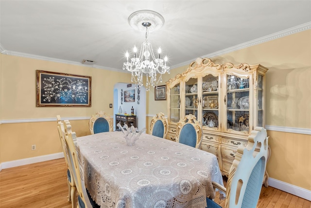 8 Wichard Blvd, Commack, NY 11725 - dining space featuring a chandelier, light wood-type flooring, baseboards, arched walkways, and ornamental molding