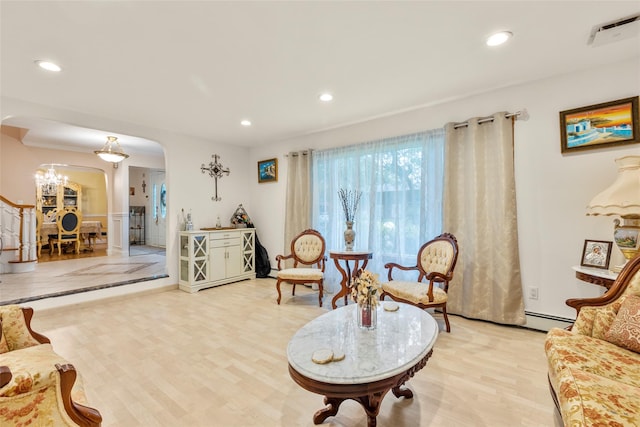 8 Wichard Blvd, Commack, NY 11725 - living room featuring arched walkways, a baseboard heating unit, recessed lighting, a chandelier, and light wood-style flooring