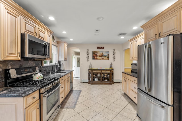 8 Wichard Blvd, Commack, NY 11725 - kitchen featuring appliances with stainless steel finishes, arched walkways, a sink, baseboard heating, and decorative backsplash
