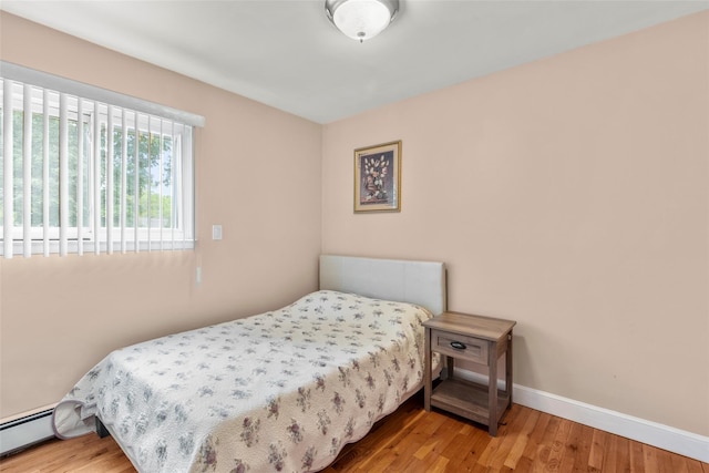 8 Wichard Blvd, Commack, NY 11725 - bedroom featuring a baseboard radiator, wood finished floors, and baseboards